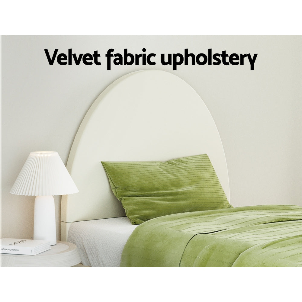 Ella Arched Single Bed Frame Cream Velvet with velvet upholstery, green bedding, and white bedside lamp