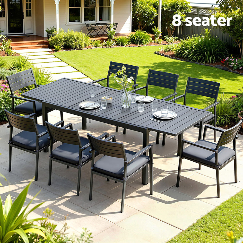 Outdoor Dining Set 9PCS Aluminum Extendable Table Chairs Patio Furniture with black cushions in garden setting with tableware