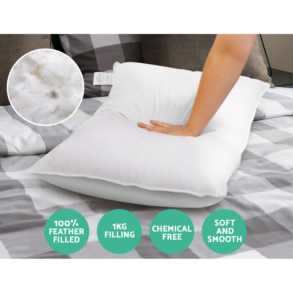 Set of 2 Goose Feather and Down Pillows - White shown on bed with hand pressing pillow to show softness and filling details