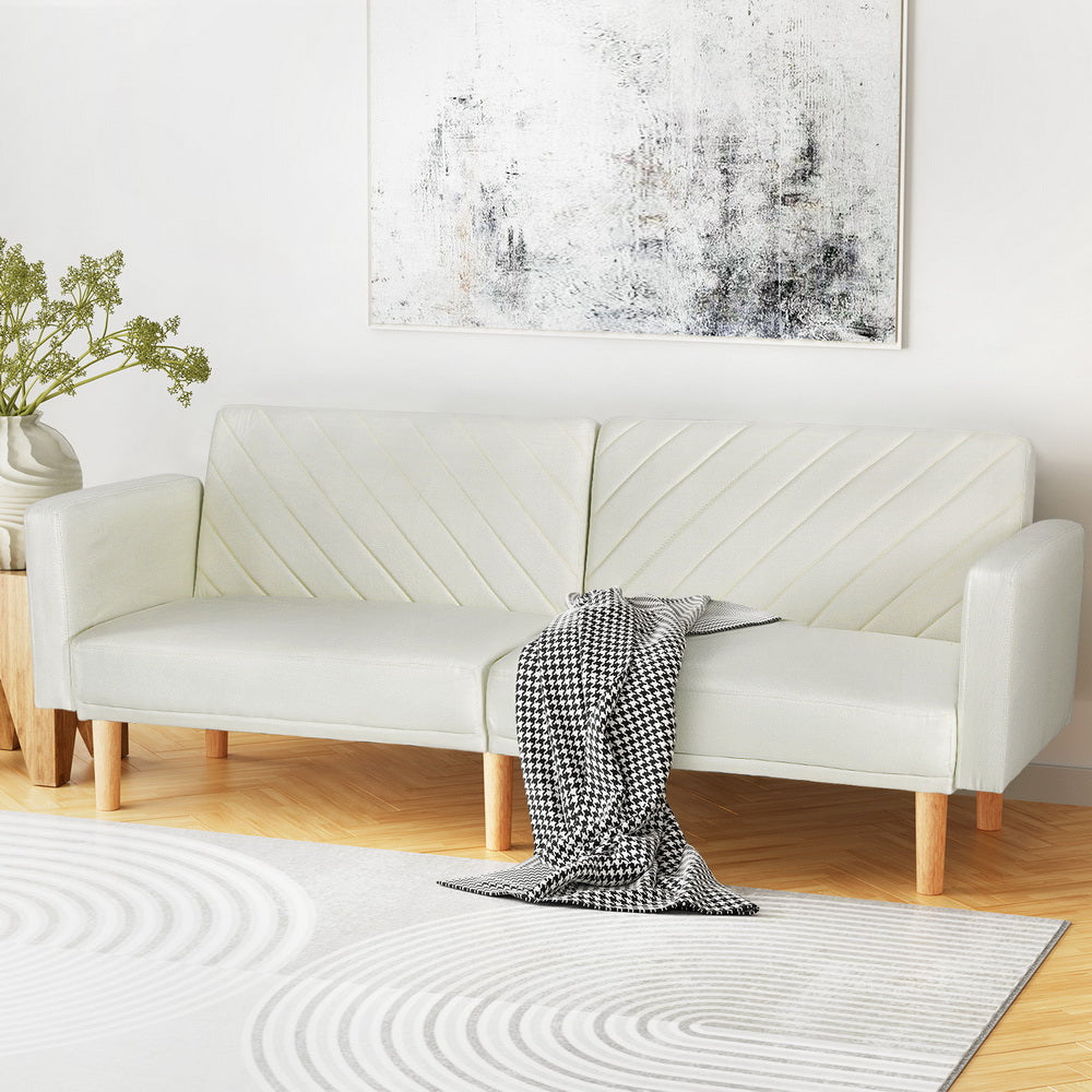 Sofa Bed 195CM Beige Faux Linen with wooden legs and quilted backrest, shown with black and white throw blanket in bright room