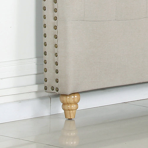 Close-up of wooden leg and studded edge on beige fabric of King Size | Sean Headboard by Bedzy bedroom furniture.
