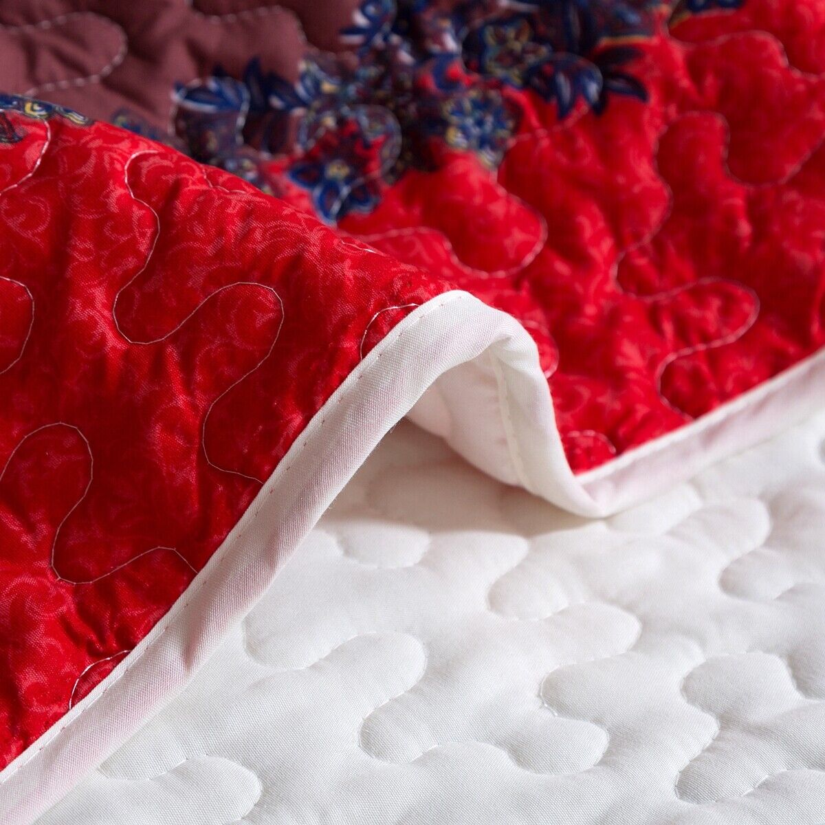 Close-up of Rusty Boho floral Chic 3 Pc Bedspread & Pillow Cover Set showing quilted white reverse and red floral front fabric texture