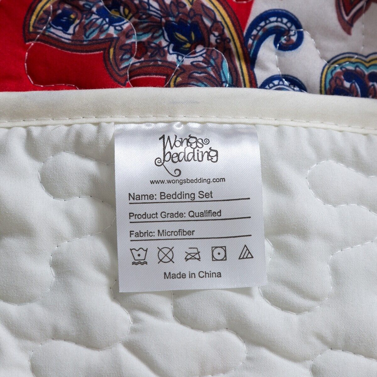 Close-up of care label on Rusty Boho floral Chic 3 Pc Bedspread & Pillow Cover Set showing fabric and washing instructions
