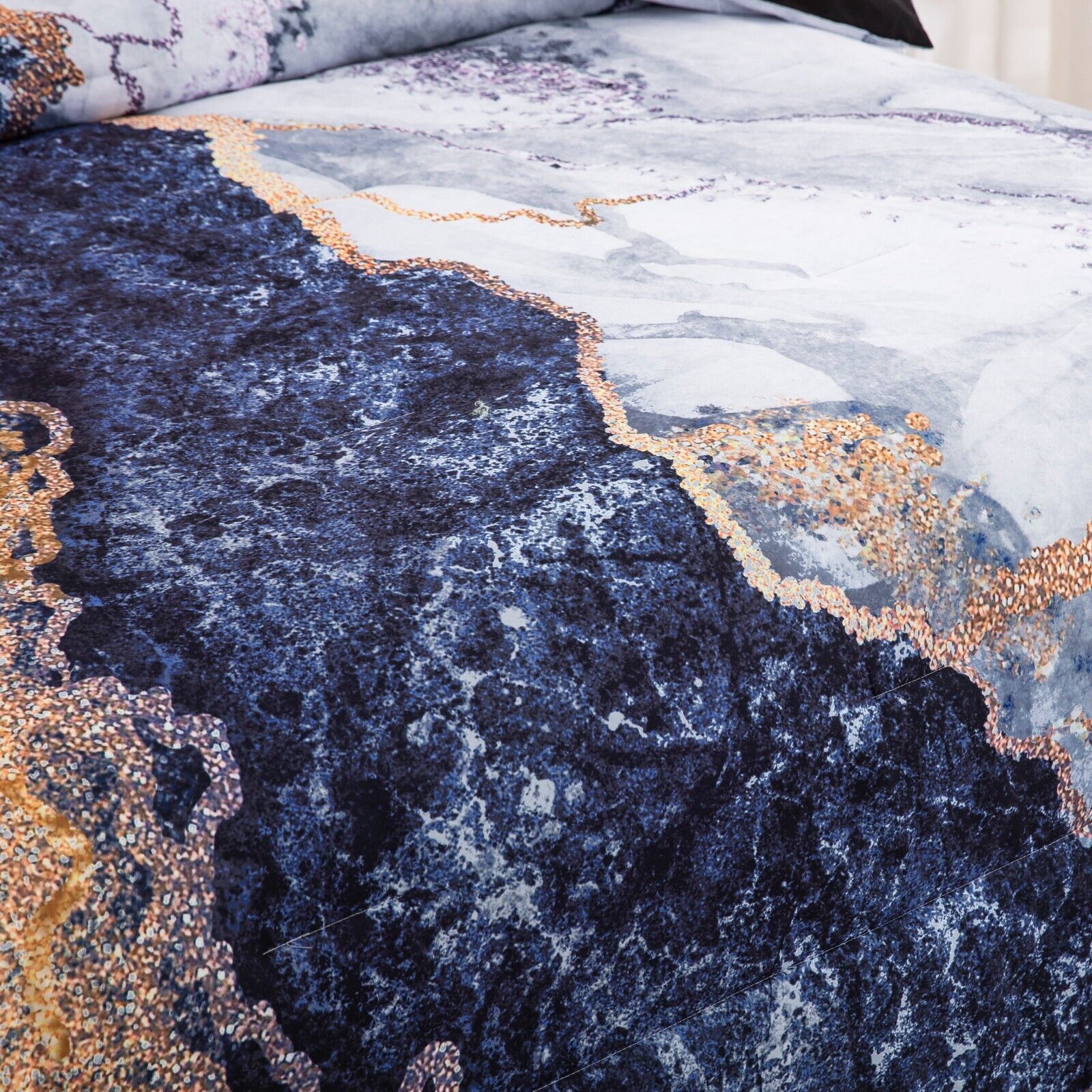Close-up of Blue Marble Comforter Set, King Size, Retro Watercolor 3-Piece Bedding Ensemble in navy and gold tones on bed