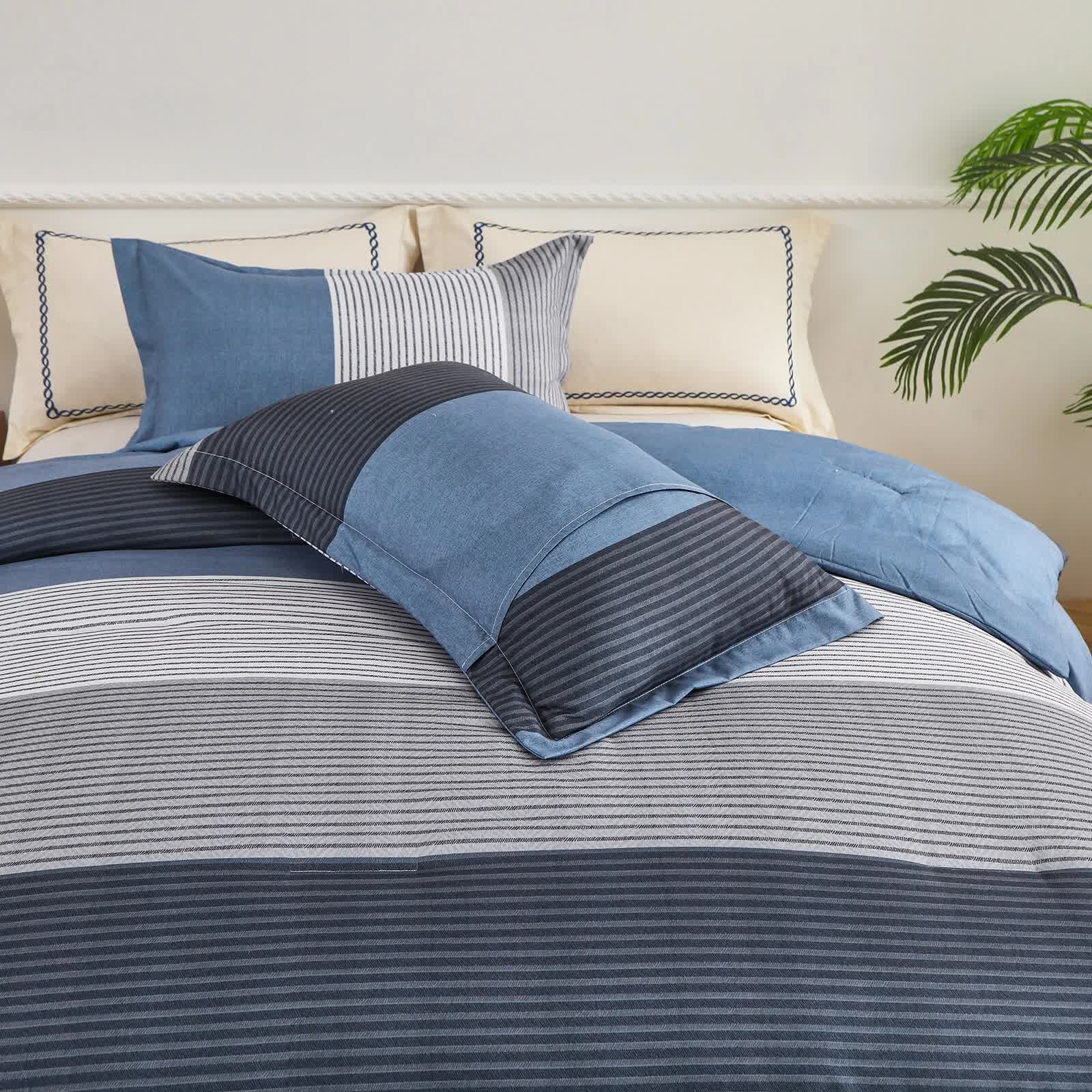 Coastal Drift striped Comforter Bundle – Breezy 3‑Piece Bedding in blue and gray stripes on a made bed with pillows and a plant nearby