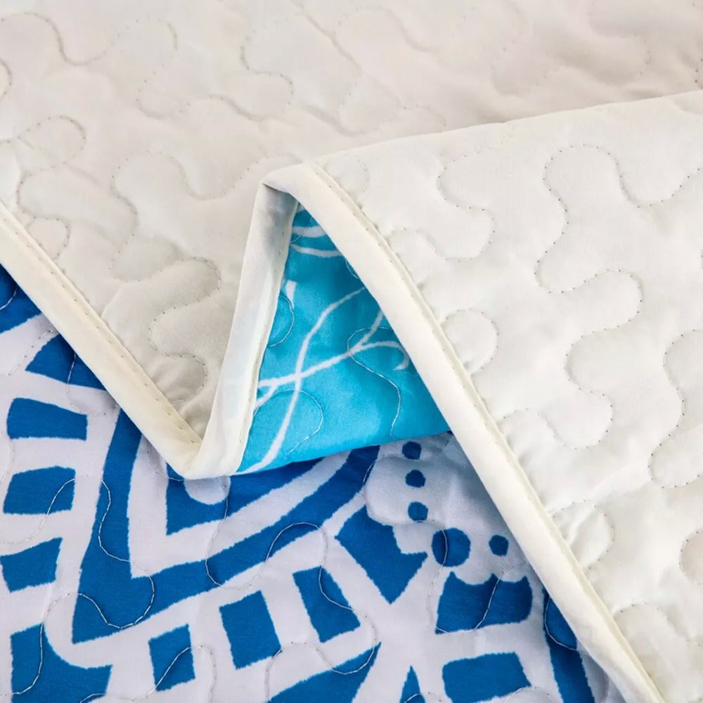 Close-up of Xciting Quilted bedspread and pillowcovers set: Add Some Fun - Queen size showing reversible blue patterned and white quilted textures.