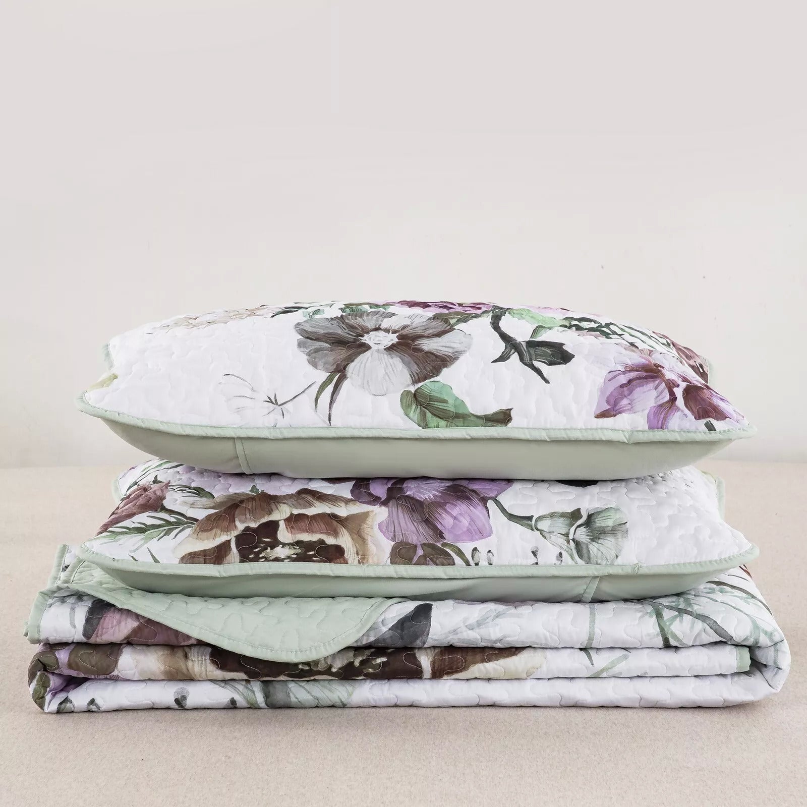 Deluxe Quilted Bedspread and Pillowcases Set: Infuse Your Bedroom with Style - Queen size in floral print, folded on neutral background