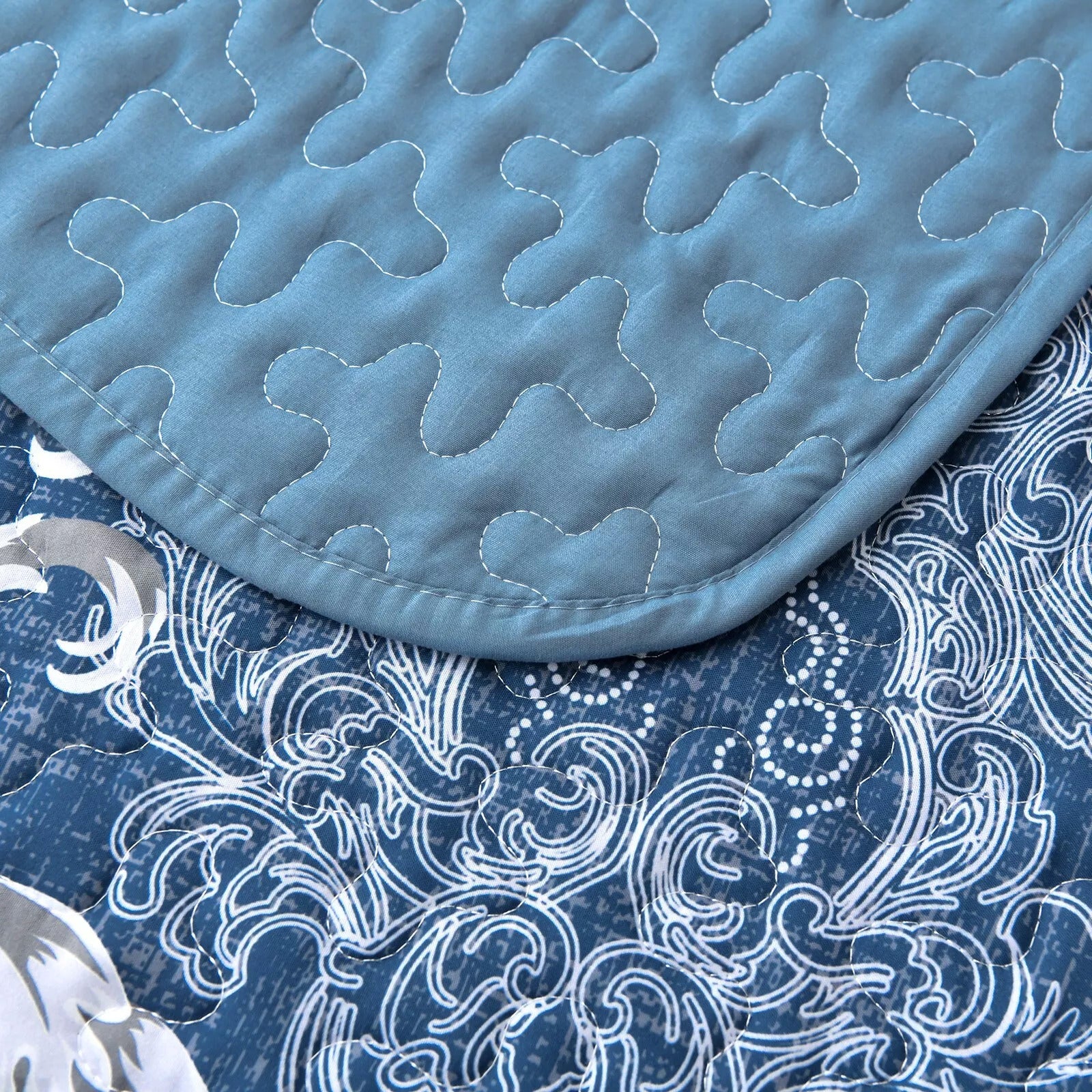 Close-up of Alluring Quilted bedspread and pillowcovers set: Luxurious Bedroom Addition - Queen size with blue quilt stitching and patterned fabric