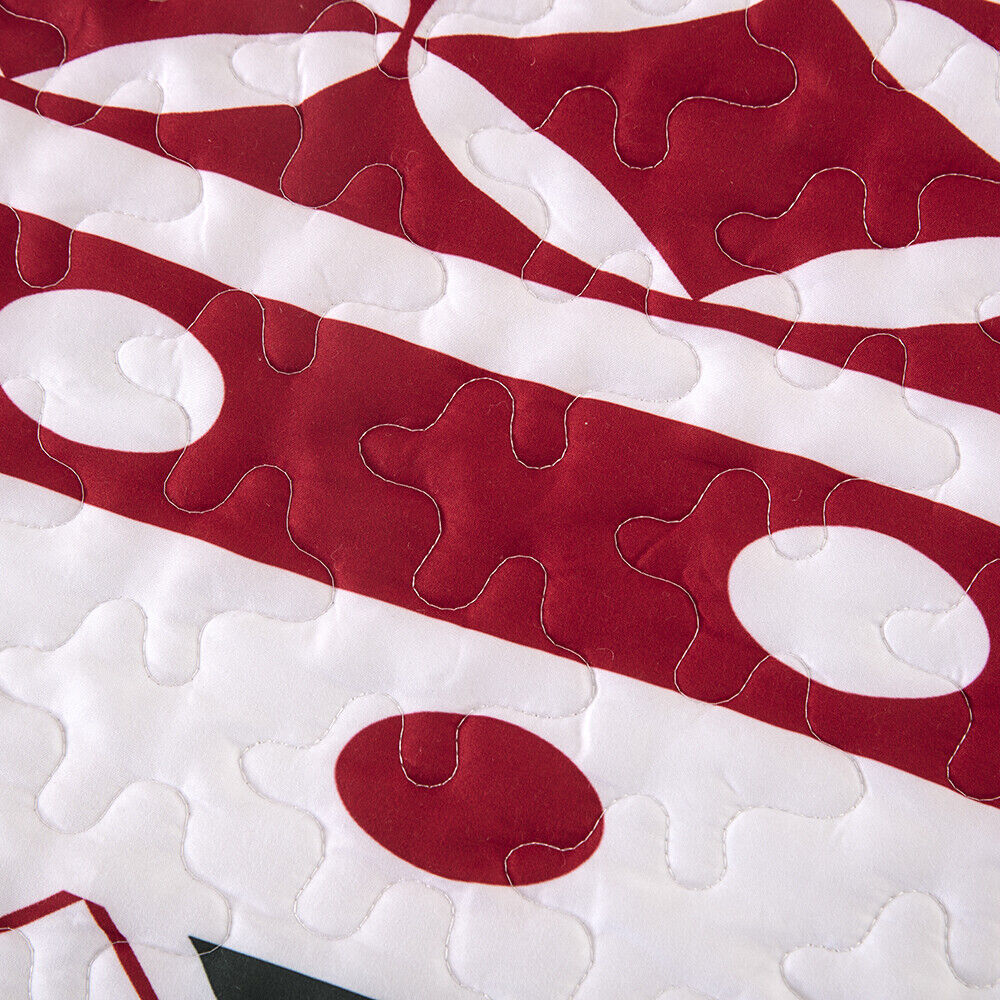 Close-up of quilted fabric detail in red and white from the Vintage Christmas Print Queen Bedspread Set by Bedzy