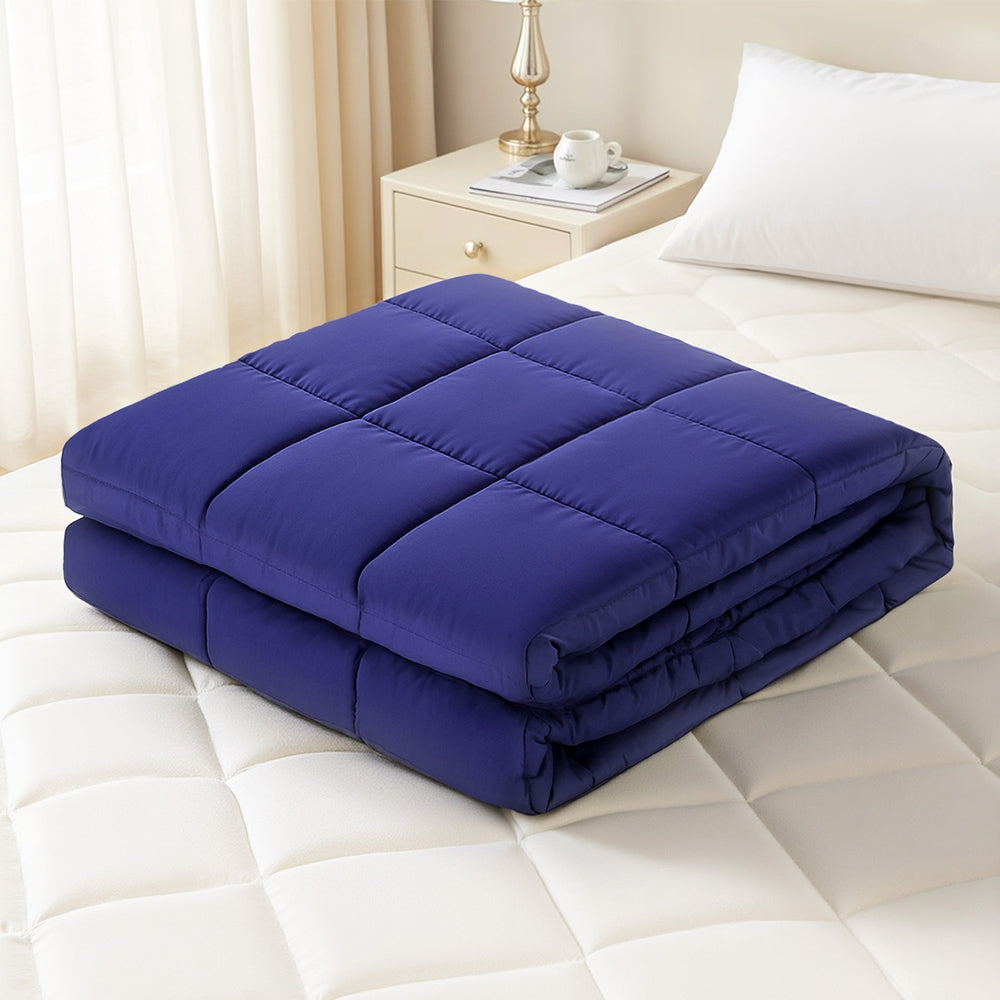 Weighted Blanket 9KG Kids Adults Heavy Gravity Relax Calm Blue folded on white mattress with bedside table and lamp