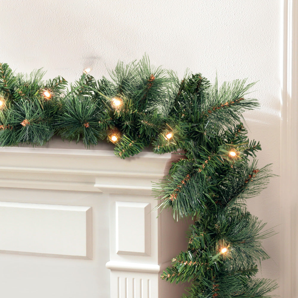 1.8m Christmas Garland with LED lights Party Xmas Decorations draped over white mantel with warm glowing fairy lights