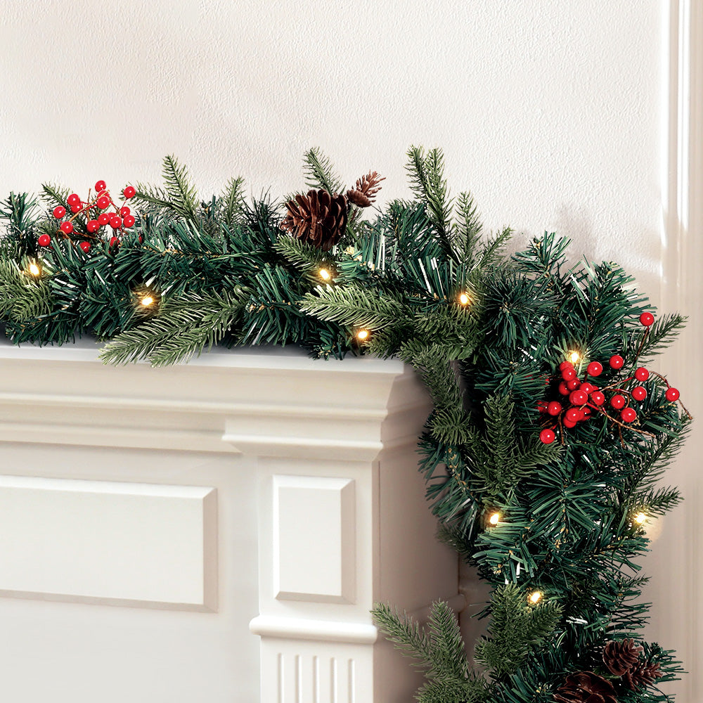 2.4m Christmas Garland with LED Lights Decorations Xmas Party draped on mantel with pine cones, red berries, and warm lights