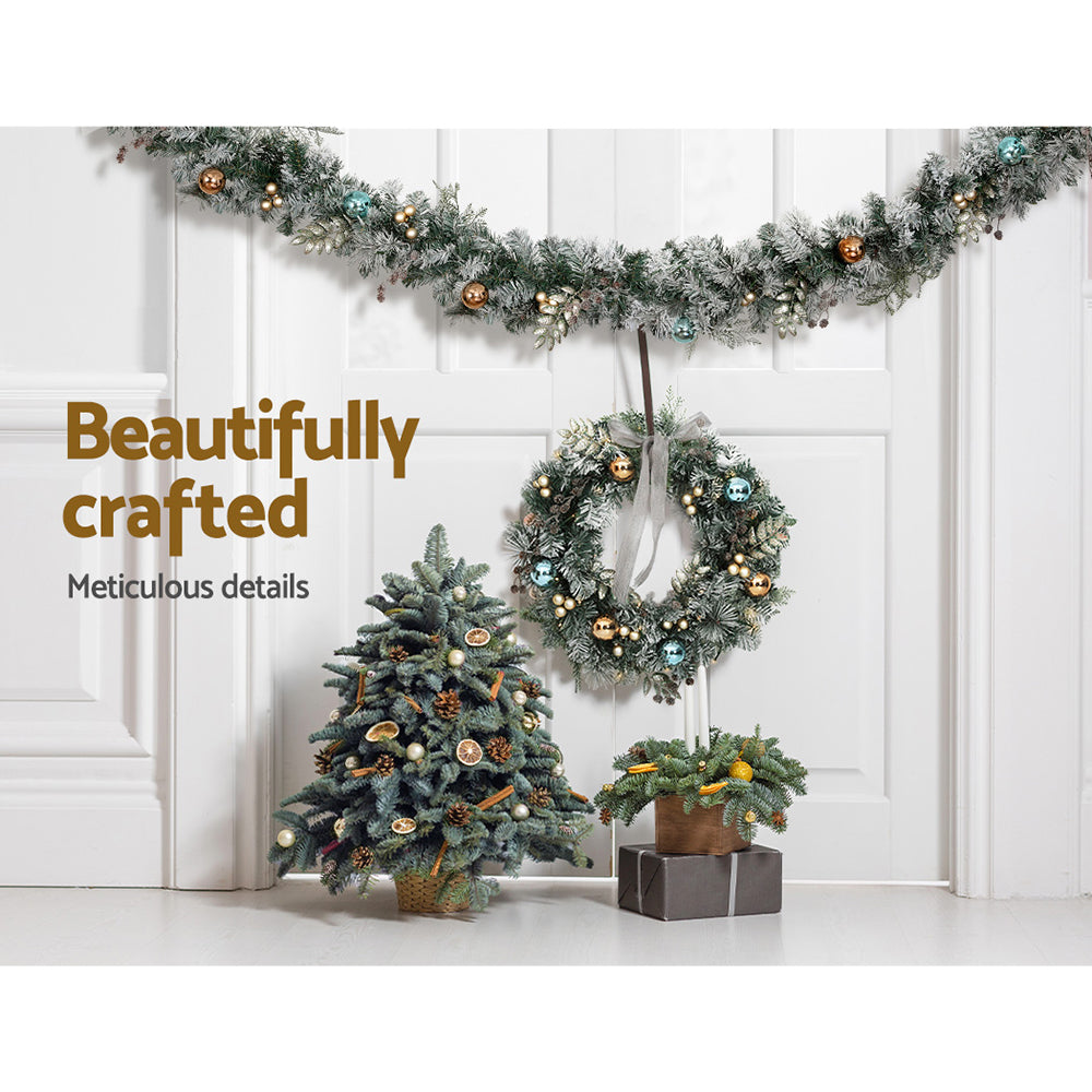 2.7m Christmas Garland with LED Lights Snowy Decoration Xmas Party draped with ornaments above wreath and miniature tree on white panel background
