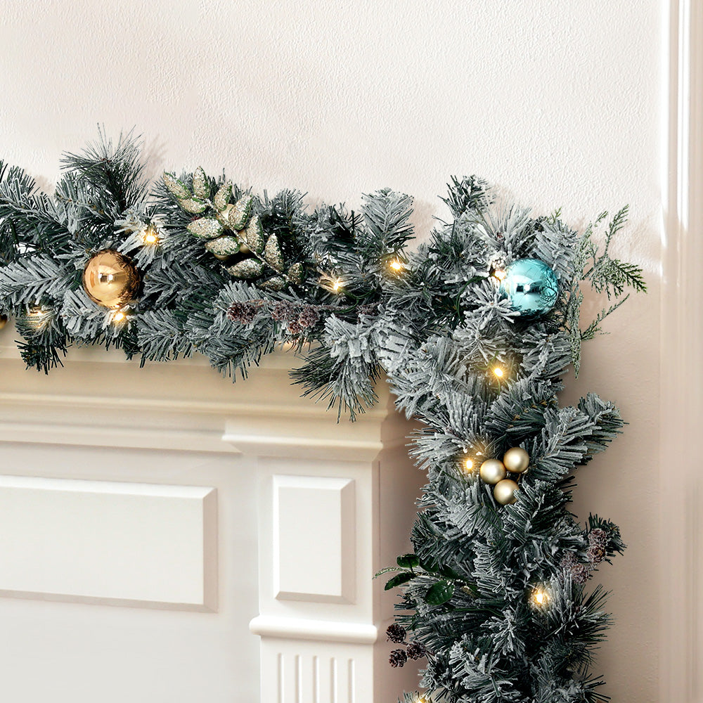 2.7m Christmas Garland with LED Lights Snowy Decoration Xmas Party draped on white mantel with gold and blue ornaments