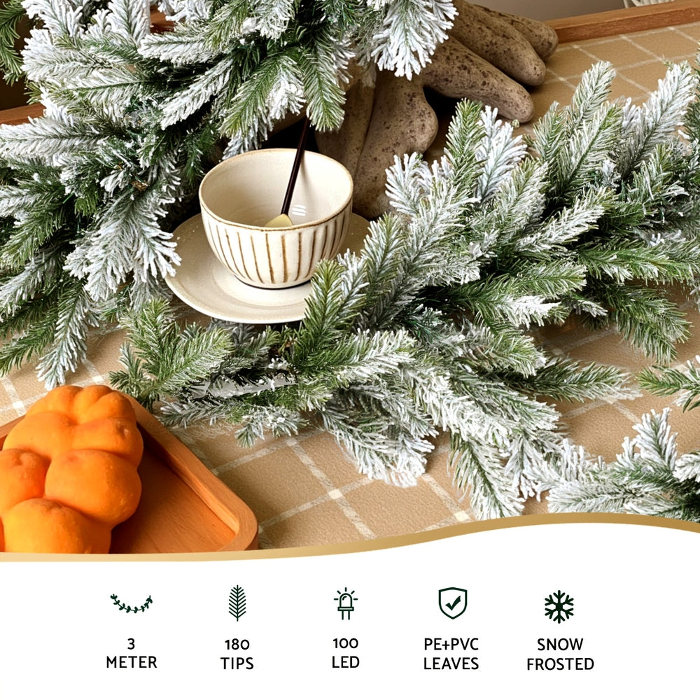 3M Christmas Garland Pre-lit LED Lights Snow Frosted Tips Decor with lifelike snow-frosted PE and PVC leaves on table.