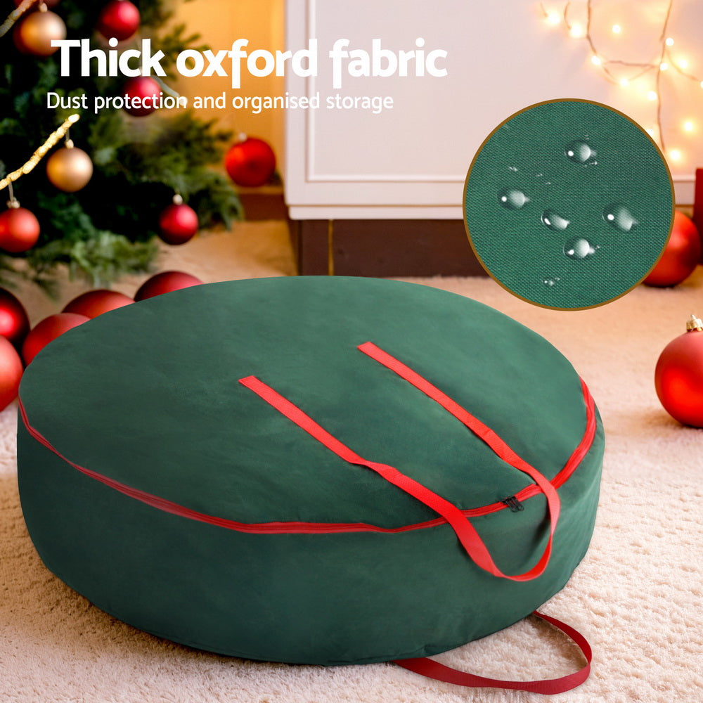 Christmas Garland Wreath Storage Bag Baubles Ornaments Container in green Oxford fabric with red handles and zipper on carpeted floor