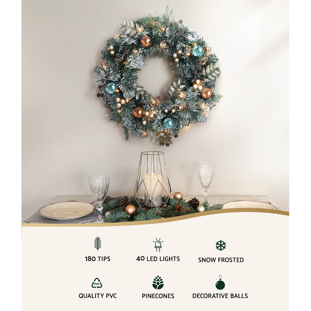 60cm Christmas Wreath with LED Lights Snowy Garland Xmas Decor featuring pinecones, frosted tips, and decorative balls on wall above table setting
