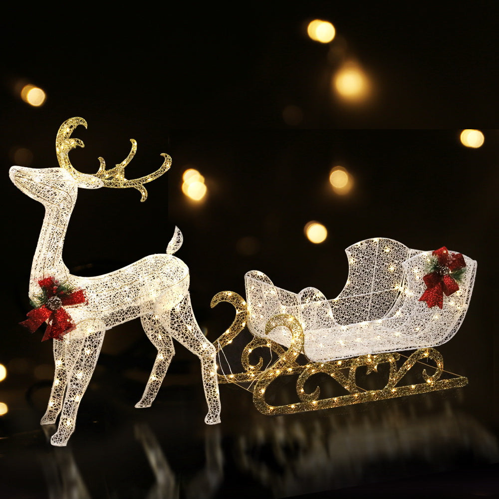 215 LED Christmas Lights Reindeer Sleigh Decorations with warm white lights, gold accents, and red ribbon bows on black background