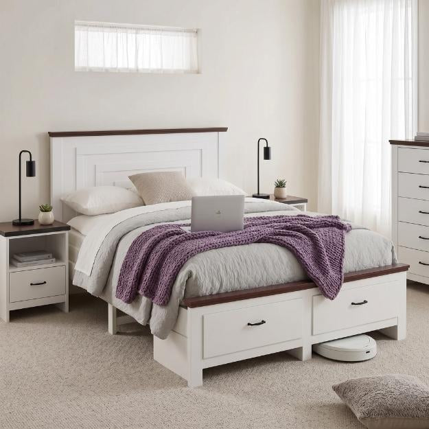 Bedzy white timber queen bed frame with under-bed storage drawers, matching white bedside tables with black lamps, and a tallboy chest of drawers in a modern bedroom.