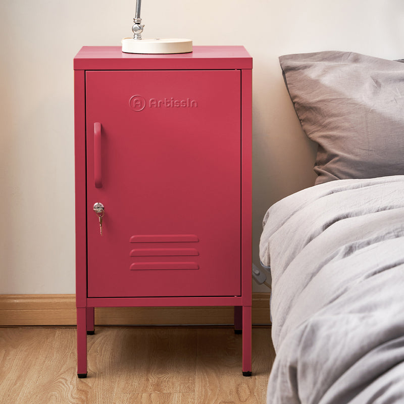 Bedside Table Metal Cabinet - MINI Pink with lockable door, industrial style design, placed next to gray bedding on wooden floor