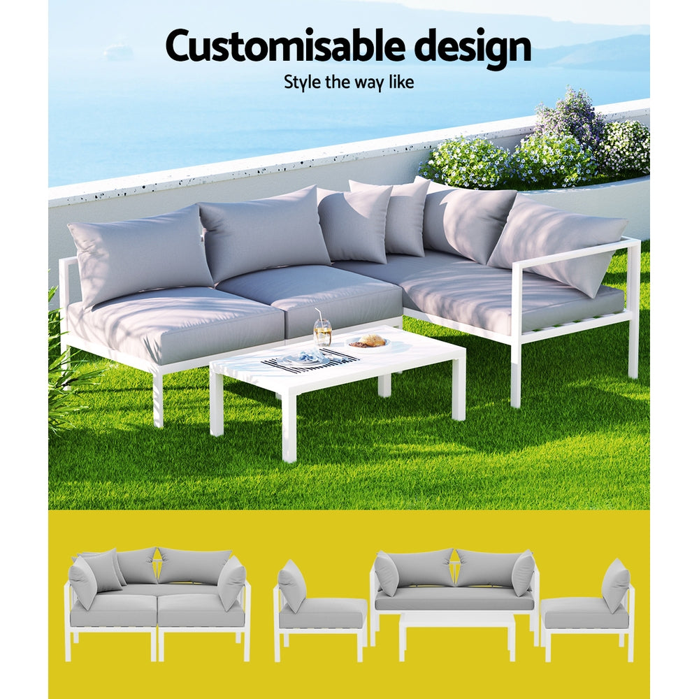 Airlie 4 Seat Aluminium Outdoor Sofa and Table Set White with light cushions on green grass and ocean view background