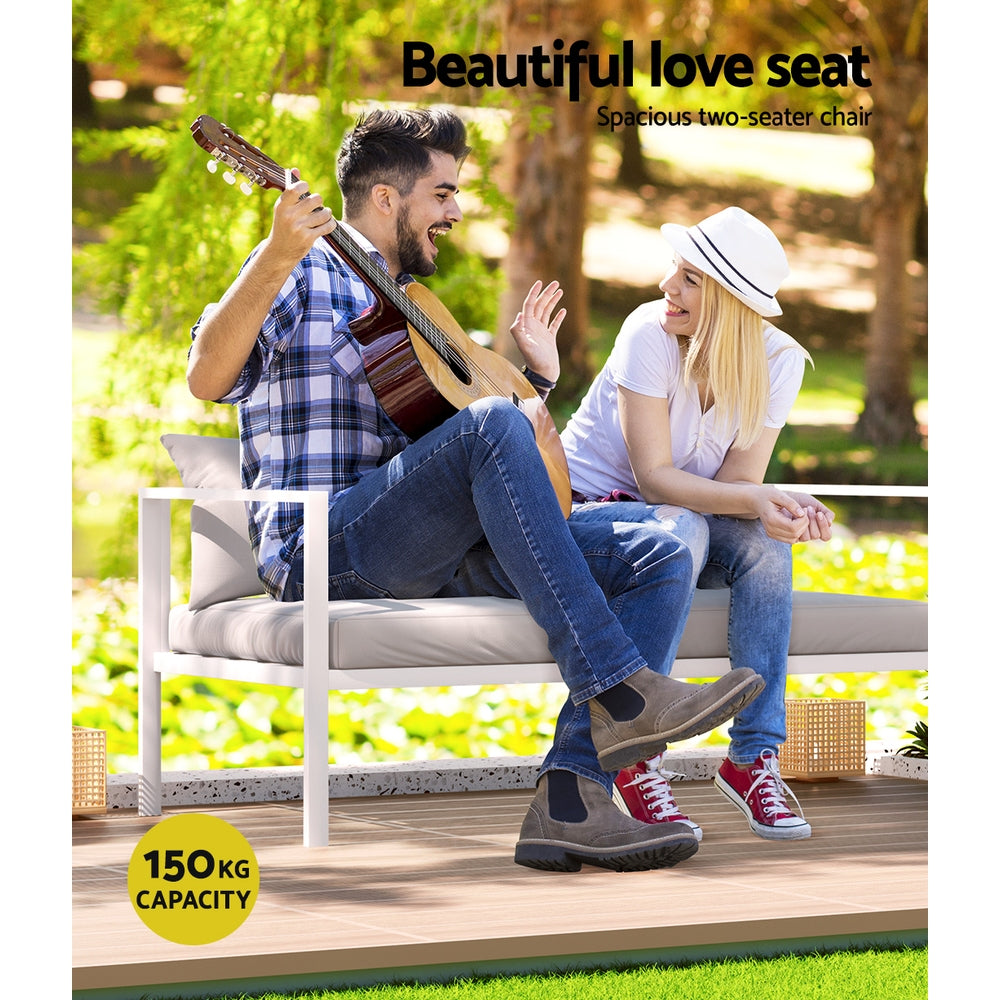 Airlie 4 Seat Aluminium Outdoor Sofa and Table Set White with cushioned two-seater chair in sunny garden setting