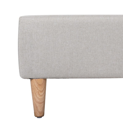Close-up of beige fabric upholstery and wooden leg on the Zora Queen Bed Frame Base Beige, bedroom furniture by Bedzy
