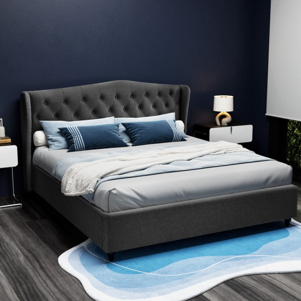 Altona King Bed Frame Charcoal with tufted wing headboard, upholstered base, styled in a modern bedroom setting with blue accents