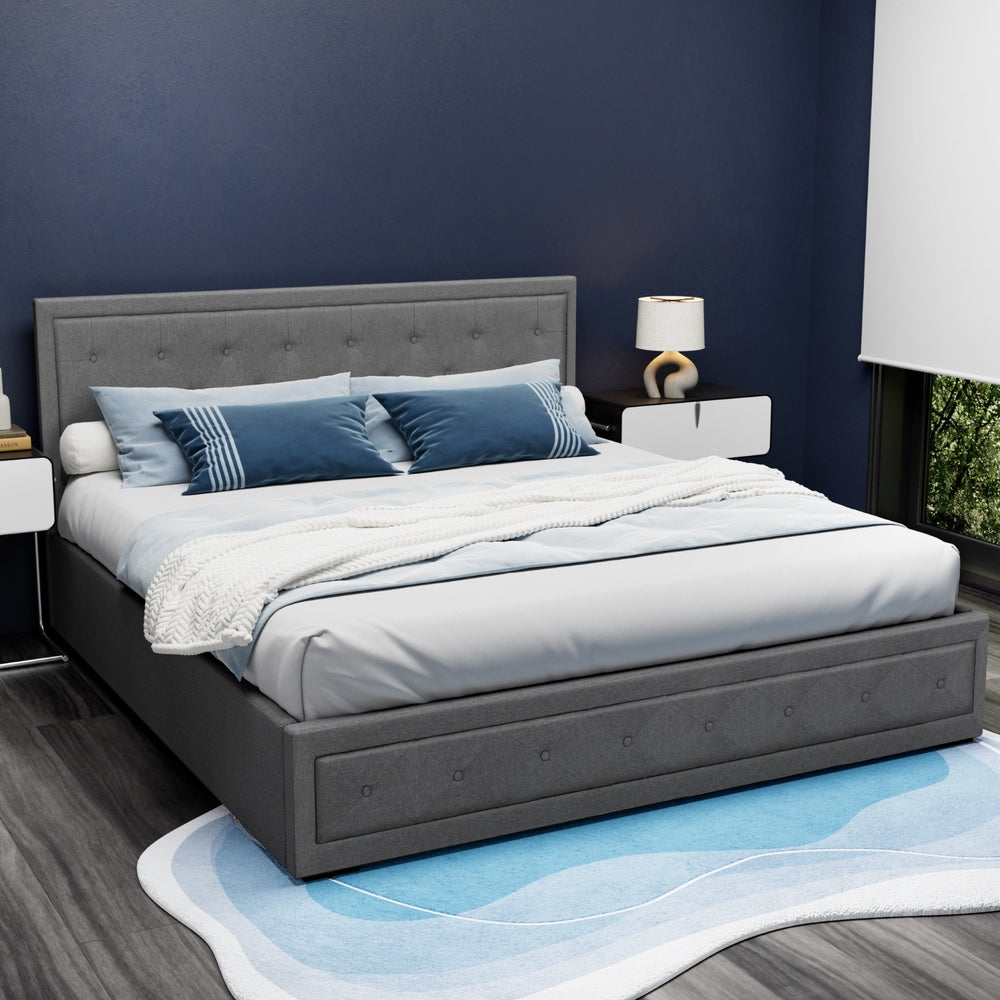 Bronte Storage King Bed Frame Grey with tufted headboard, gas lift storage, dressed with blue pillows and white bedding in modern bedroom