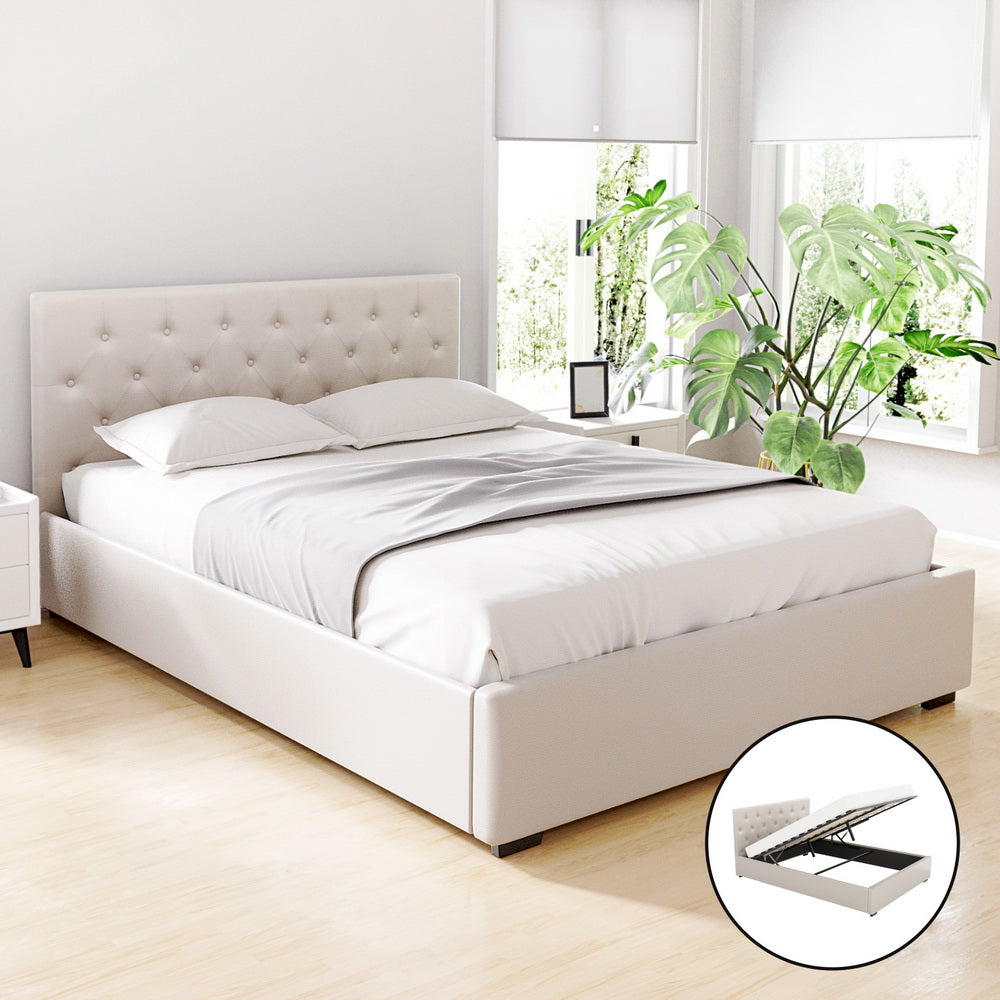 Dorilla Gas Lift Storage Queen Bed Frame - Beige with tufted headboard in a bright bedroom setting with plants and white bedding