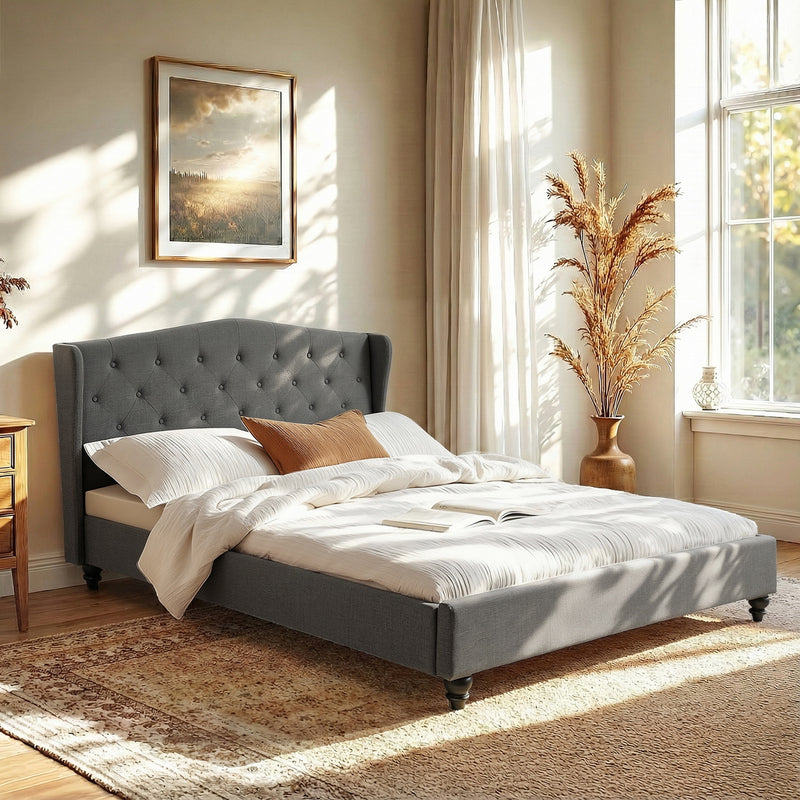 Pierre Queen Bed Frame with Wingback Headboard – Grey in a sunlit bedroom with white bedding and decorative pillows