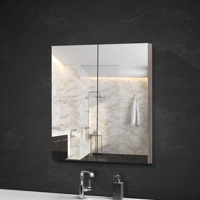 Bathroom Mirror Cabinet 600x720mm Oak with mirrored doors and oak frame mounted on dark tiled bathroom wall