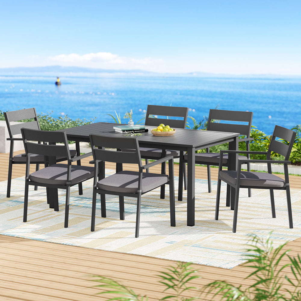 Outdoor Dining Set 7 Piece Aluminum Table Chairs Setting Black with six cushioned chairs on outdoor deck by water view