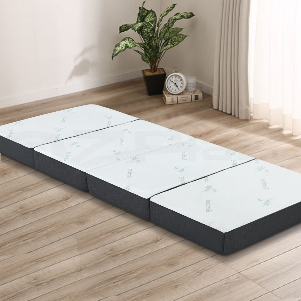Portable Mattress Folding Foldable Foam Floor Bed Tri Fold 180cm laid flat on wooden floor in bright room.