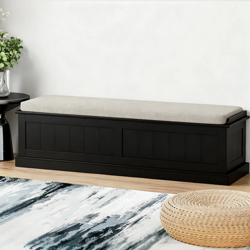 Storage Ottoman Blanket Box 140cm Fluted Black with cushioned top in a bedroom setting with rug and side table.
