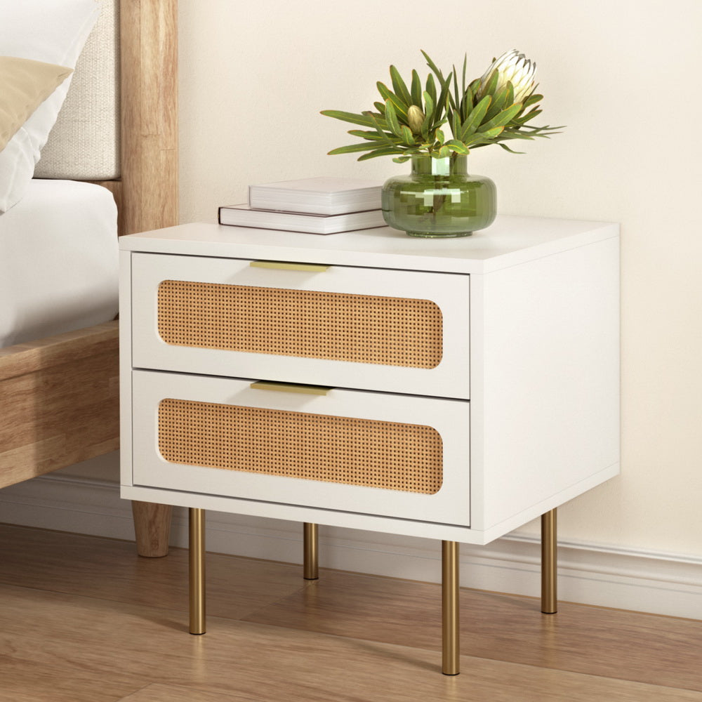 Byron Rattan Bedside Table – White & Pine with two drawers, rattan detailing, gold legs, and styled with books and vase