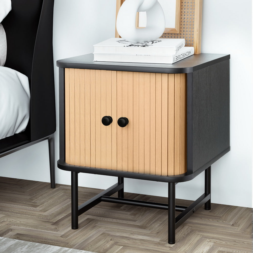 Bedside Table with Sliding Fluted Doors – Black & Pine Finish featuring black frame, pine sliding doors, and round knobs in bedroom setting