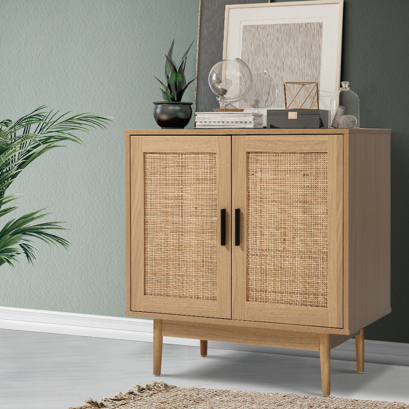 Rattan Sideboard Cabinet in oak finish with woven rattan doors, standing on tapered legs, decorated with plants and decor items