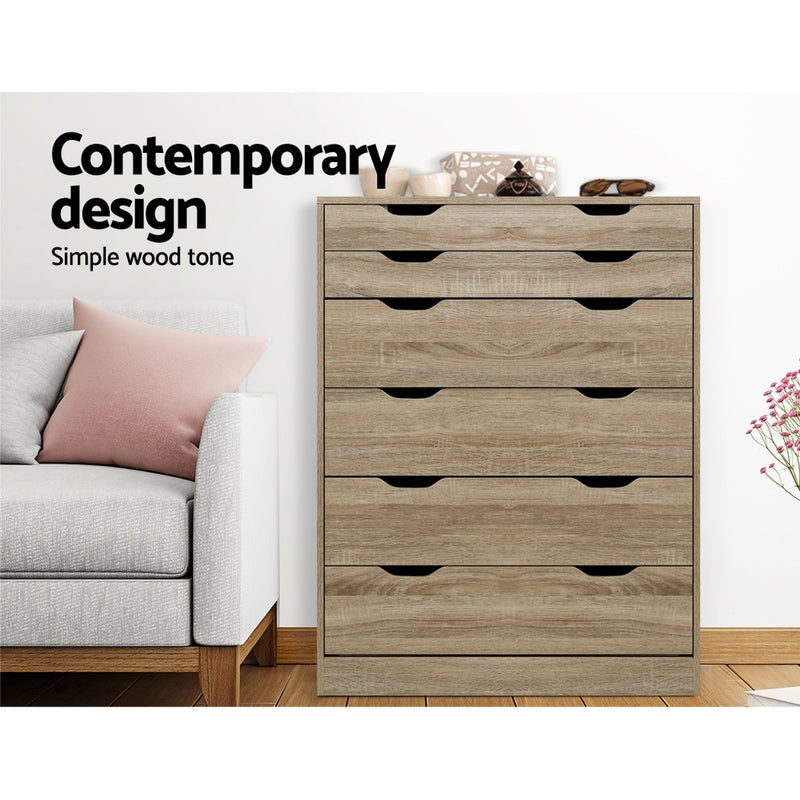 6 Drawer Tallboy Storage Dresser Oak with six spacious drawers set against a white wall next to a gray sofa