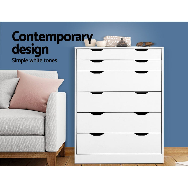 6 Drawer Tallboy Storage Dresser White with modern cutout handles, shown in bedroom setting with sofa and decorative items