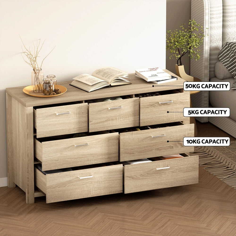 7 Drawer Lowboy Storage Dresser Oak with labeled drawer weight capacities in a bedroom setting next to sofa