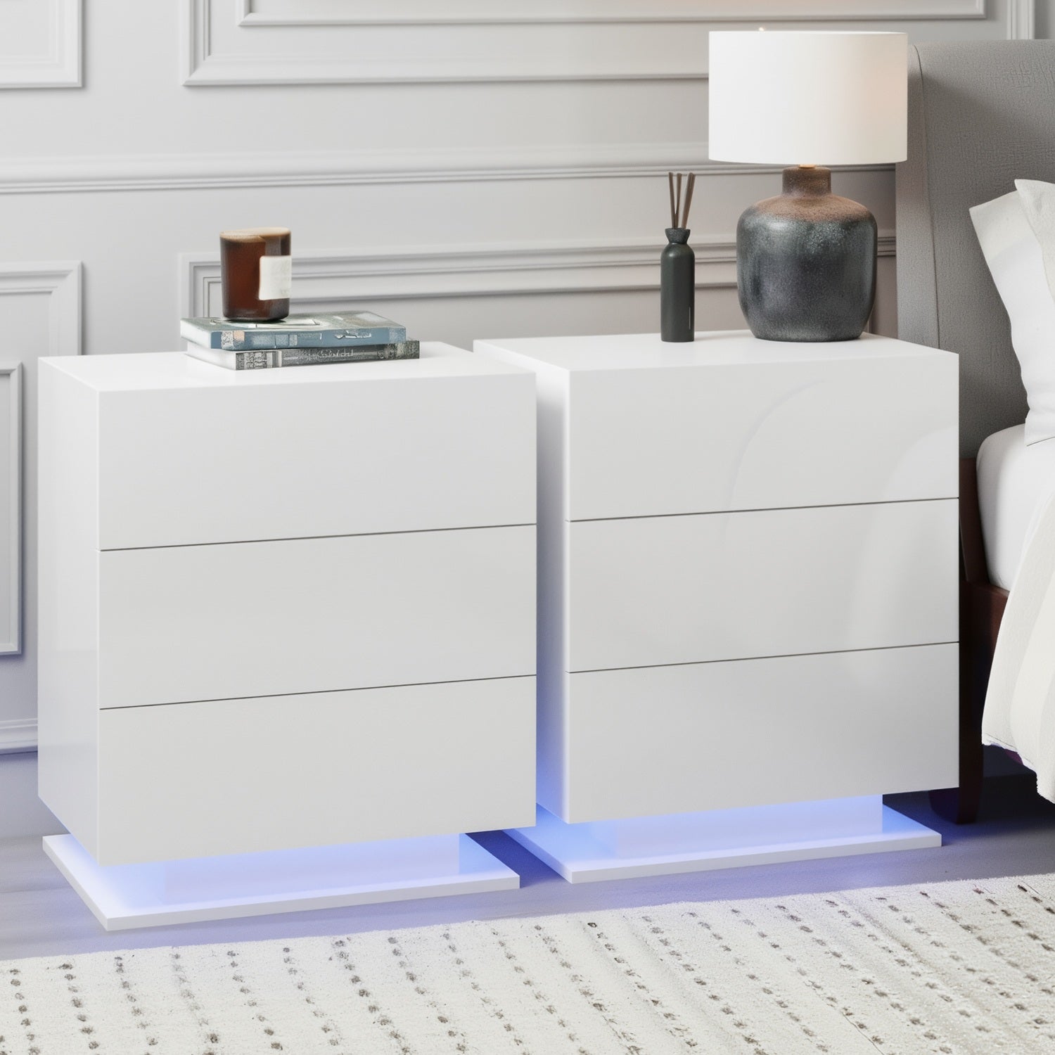 2x Bedside Table LED 3 Drawers - MORI White with built-in blue LED lighting and three smooth drawer fronts in bedroom setting