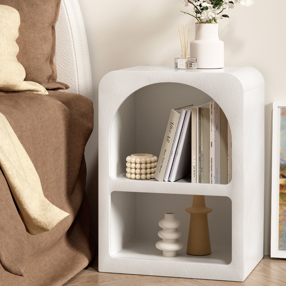 Arched Textured Bedside Table White with two shelves, styled with books, decorative vases, and placed beside a bed in bedroom setting