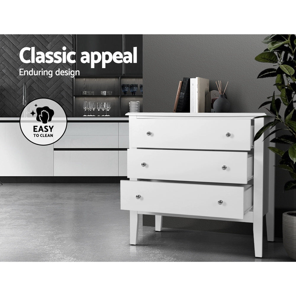 Chest of 3 Drawers Storage Cabinet White with silver knobs, standing on tapered legs in a modern indoor setting