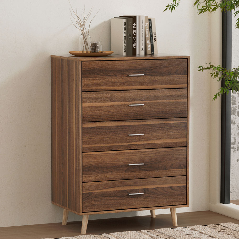 5 Chest of Drawers - MIRI Walnut with five smooth glide drawers, sleek handles, and angled wooden legs in a bedroom setting