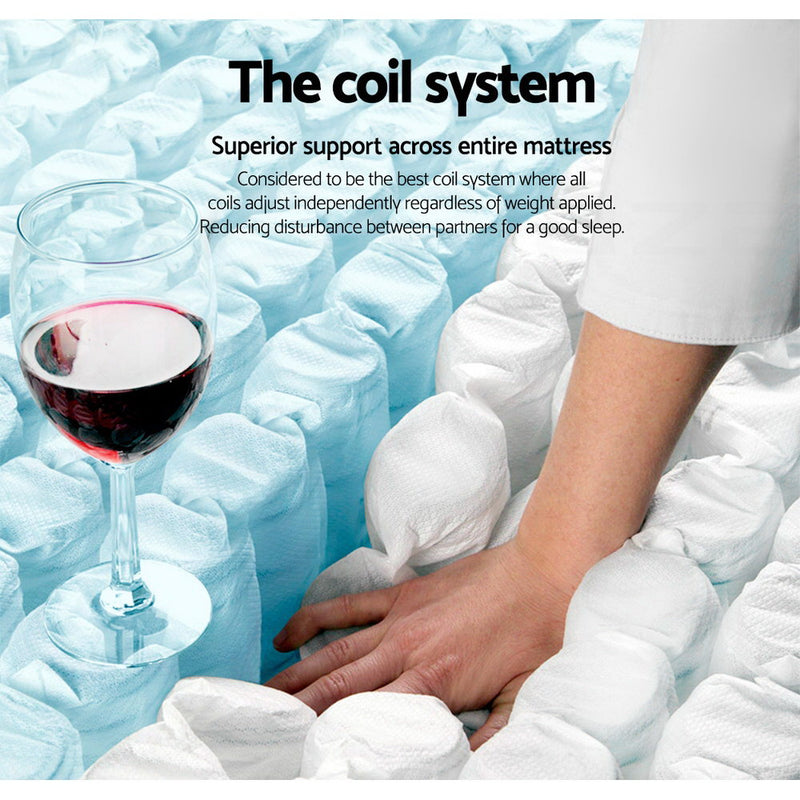 Close-up of coil system in Mykonos Euro Top Pocket Spring Mattress 30cm Thick - Queen with hand pressing springs and wine glass nearby