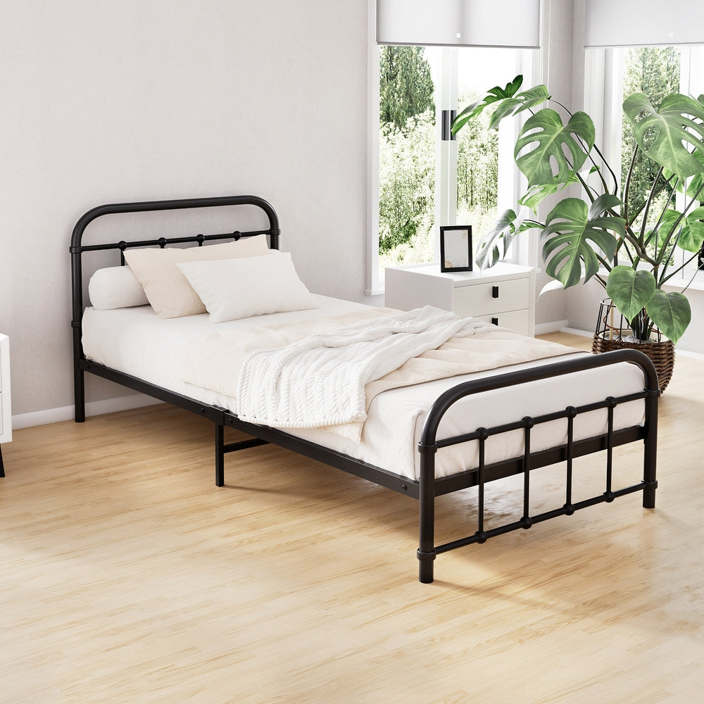 Leo Metal Single Bed Frame Black in a bright bedroom setting with white bedding and wooden floorboards.