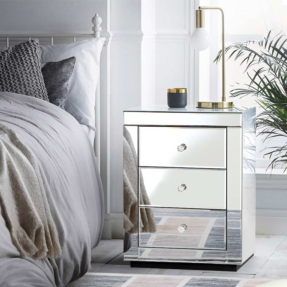 Mirrored Bedside Table Drawers Furniture Mirror Glass Presia Silver with three drawers, crystal knobs, and modern decor on top.