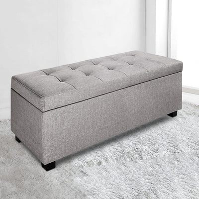 Large Fabric Storage Ottoman - Light Grey with tufted top and black feet on white textured rug in bright room