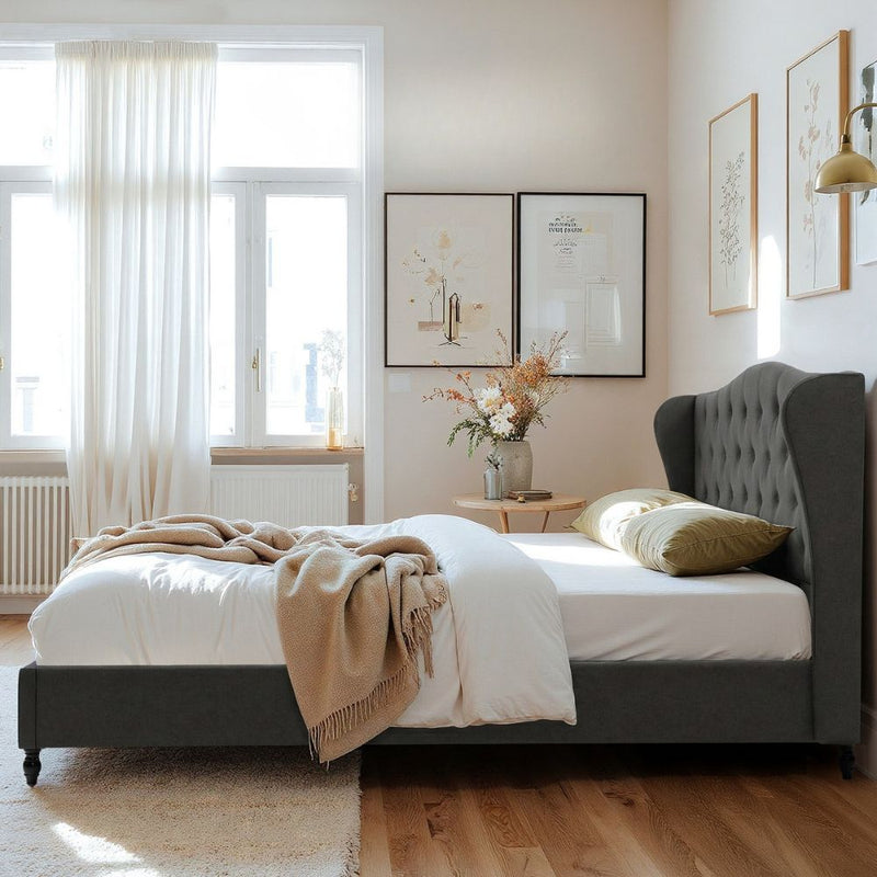 Pierre Double Bed Frame with Wingback Headboard – Grey, upholstered bedroom furniture with tufted backrest and wooden legs in a sunlit room